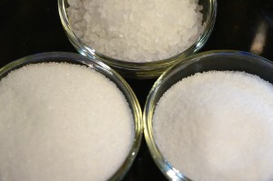 Crystals of different sizes: fine canning salt, coarse sea salt, and table salt.